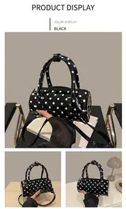 Detailed views of a black polka dot cylinder bag with dual handles and crossbody strap
