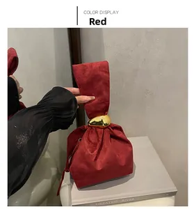 Détail du sac seau en daim rouge avec une grande boucle en métal doré élégant