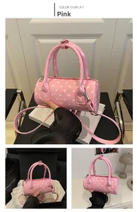 Detailed view of pink polka dot barrel bag with silver hardware and adjustable strap