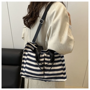 Detail of navy striped canvas tote bag showing high-quality texture and leather handles