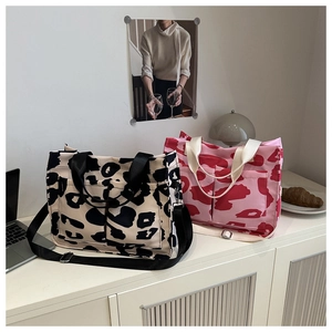 Due borse tote in tela con motivo mucca rosa e nero dotate di tasche e tracolle