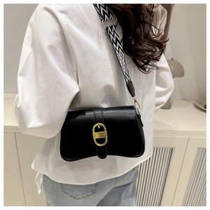 Detail of black leather crossbody bag with gold buckle and geometric woven strap