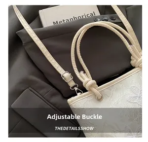 Détail de la boucle réglable sur un sac en dentelle blanche avec broderie papillon