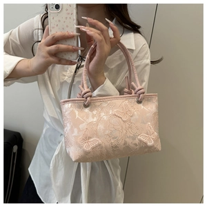 Close-up of pink lace shoulder bag featuring 3D butterfly embroidery and metal ring handle