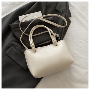 Détail d'un sac seau brodé blanc crème avec poignée nouée et œillets métalliques fins