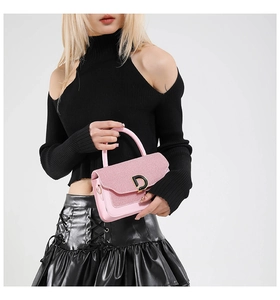 Detail of pink PU leather handbag featuring woven flap texture and a metallic D-ring buckle