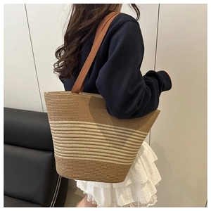 Close-up of a striped straw tote bag with brown straps for summer beach vacations