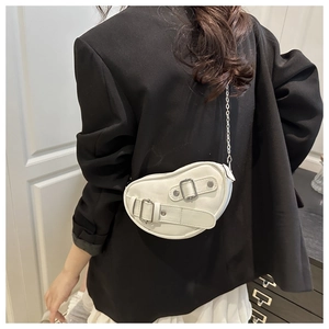 Sac bandoulière blanc en forme de haricot avec chaînes argentées et boucles sur modèle