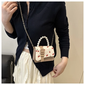 Détail du mini sac beige en cuir avec imprimé cerise et poignée en perles