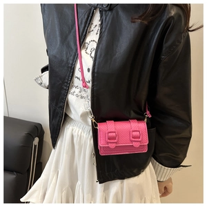 Detail of pink mini crossbody bag featuring diagonal woven texture and acrylic chain