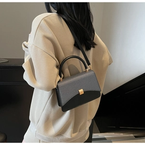 Sac carré chic bicolore en cuir noir et tissu gris porté par un mannequin femme
