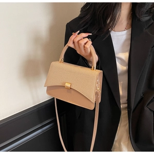 Détail du sac beige avec rabat tissé et boucle carrée en métal doré élégante