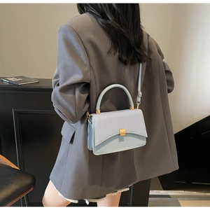 Détail d'un sac carré en patchwork bleu clair porté par un mannequin en gros plan