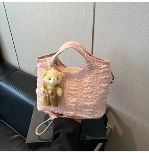 Pink pleated bucket bag detail with a cute teddy bear charm and detachable crossbody strap
