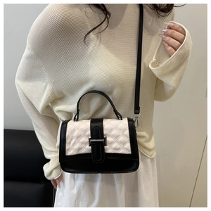 Détail du sac bandoulière matelassé noir et blanc avec fermoir métallique argenté élégant