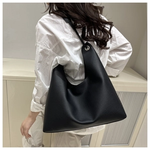 Detail of black lychee grain leather hobo bag with silver eyelets and soft texture