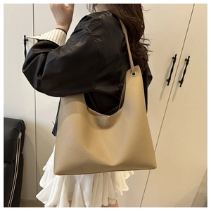 Détail d'un grand sac cabas en cuir grainé beige avec anneaux métalliques élégants
