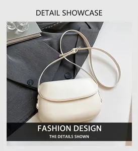Minimalist cream crossbody bag with adjustable strap on a stylish gray suit background