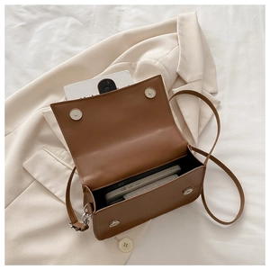 Vue intérieure d'un sac bandoulière marron montrant sa capacité pour un smartphone