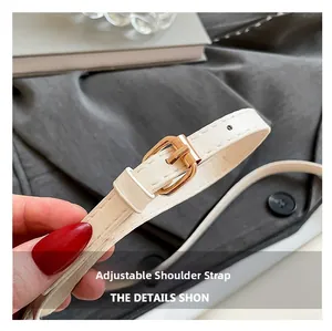 Close-up of adjustable white leather strap with premium gold metal buckle detail