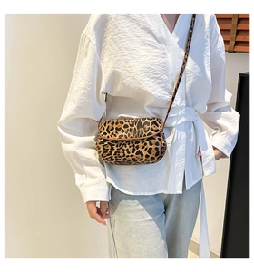 Detail shot of leopard print crossbody bag showing hair-on-hide texture and flap closure
