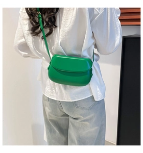 Detailed side view of the bright green minimalist mini saddle bag with adjustable strap