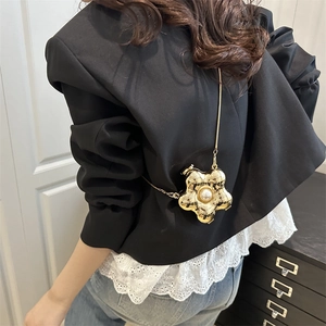 Chic gold flower clutch with pearl accent and chain strap worn over black blazer