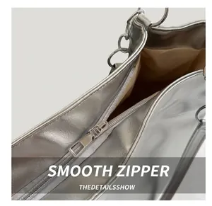 Detailed close-up of smooth silver metal zipper and chain strap on stylish tote bag