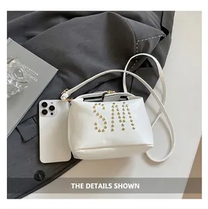 Comparaison de taille du petit sac cabas blanc avec smartphone et rivets dorés