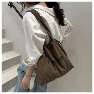 Detail of Farissa drawstring shoulder bag with side view on a minimalist staircase
