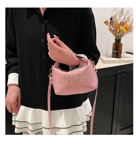 Détail du mini sac rose avec motif S en rivets dorés et finition en similicuir brillant