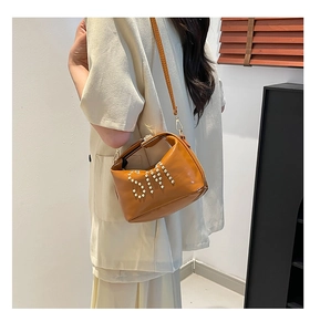 Détail du sac en cuir brillant caramel avec lettres SM en perles et fine bandoulière