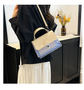 Détail du sac en PVC transparent avec rabat beige et bandoulière réglable pratique