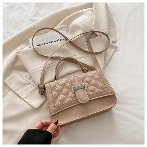 Gros plan du sac à main matelassé beige avec fermoir en H argenté et bandoulière