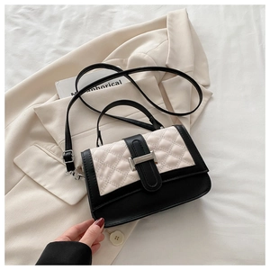 Gros plan sur le sac bandoulière bicolore avec motif matelassé et boucle argentée
