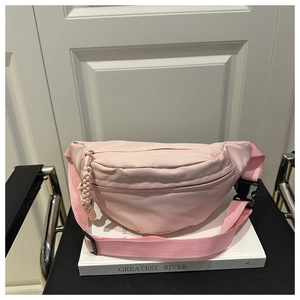 Detail view of pink nylon crossbody waist bag with adjustable strap and plastic buckle
