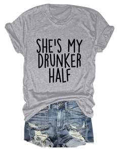 Flat lay of gray crewneck t-shirt with She’s My Drunker Half text and ripped denim shorts