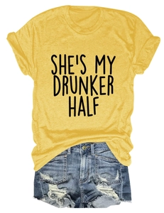 Detailed flat lay of women's yellow T-shirt with 'SHE'S MY DRUNKER HALF' text and denim shorts