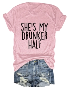 Detailed flat lay of pink t-shirt with 'SHE'S MY DRUNKER HALF' print and ripped denim shorts