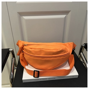 Detail of bright orange nylon crescent fanny pack with braided cord zipper puller