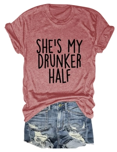 Flat lay of a red t-shirt with 'SHE'S MY DRUNKER HALF' print and ripped denim shorts
