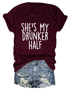 Flat lay of burgundy t-shirt with She's My Drunker Half text and denim shorts
