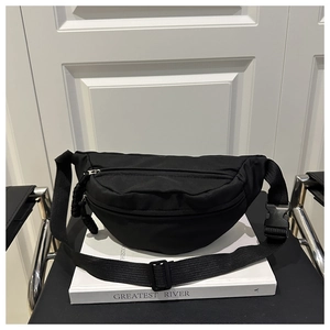 Close-up of black nylon crossbody waist bag with zipper pockets and adjustable strap