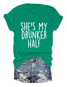 Detail of She’s My Drunker Half slogan green t-shirt paired with ripped denim shorts