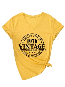 Detail of yellow V-neck T-shirt featuring retro 1976 vintage print and bottom side knot