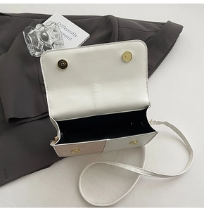 Detailed interior of minimalist two-tone crossbody bag with gold magnetic closure