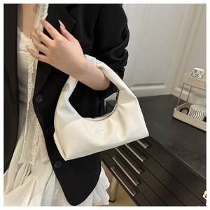 Detail of white patent leather hobo bag with glossy finish and silver zipper closure