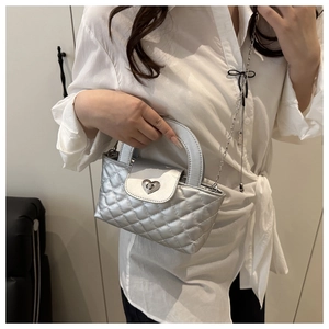 Silberne Stepptasche mit Herzverschluss an einem Model für Größe und Stil gezeigt