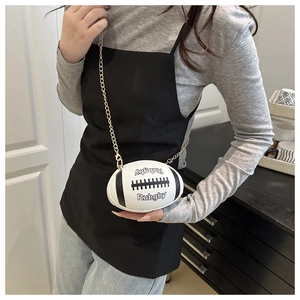 Detail of rugby-shaped mini crossbody bag with gold chain and white leather texture