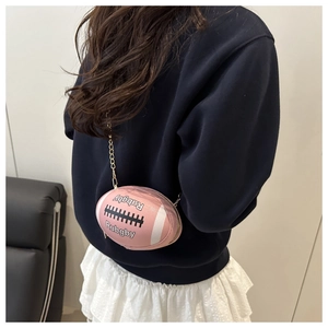 Detail view of pink rugby-shaped mini bag with gold chain strap and Rugby text